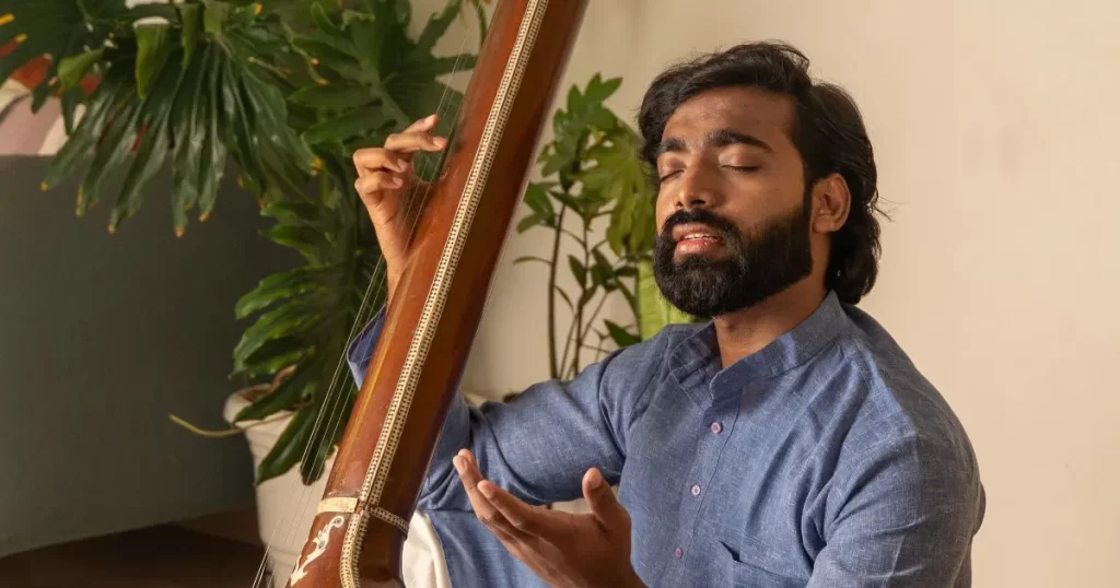 A young man practicing Indian Classical Singing with deep concentration, holding a tanpura, showcasing the soulful tradition of Hindustani music
